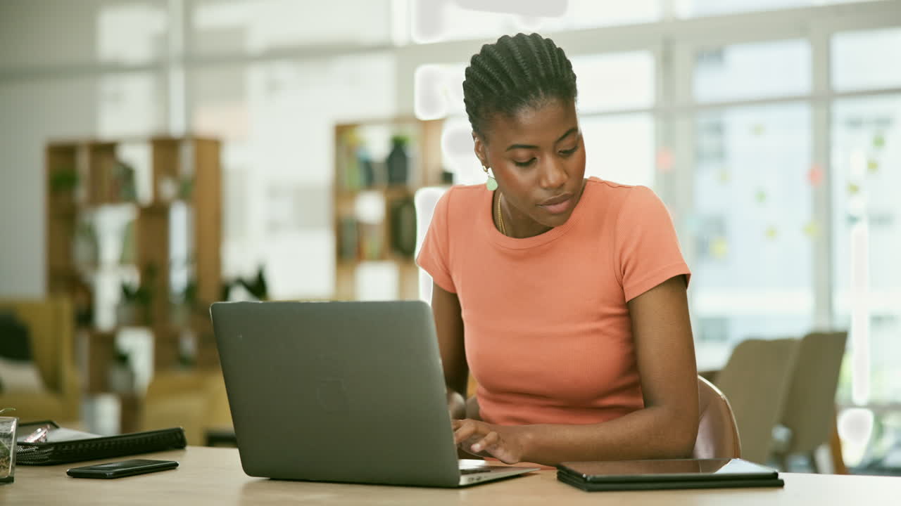 Woman working on laptop and tablet in modern office