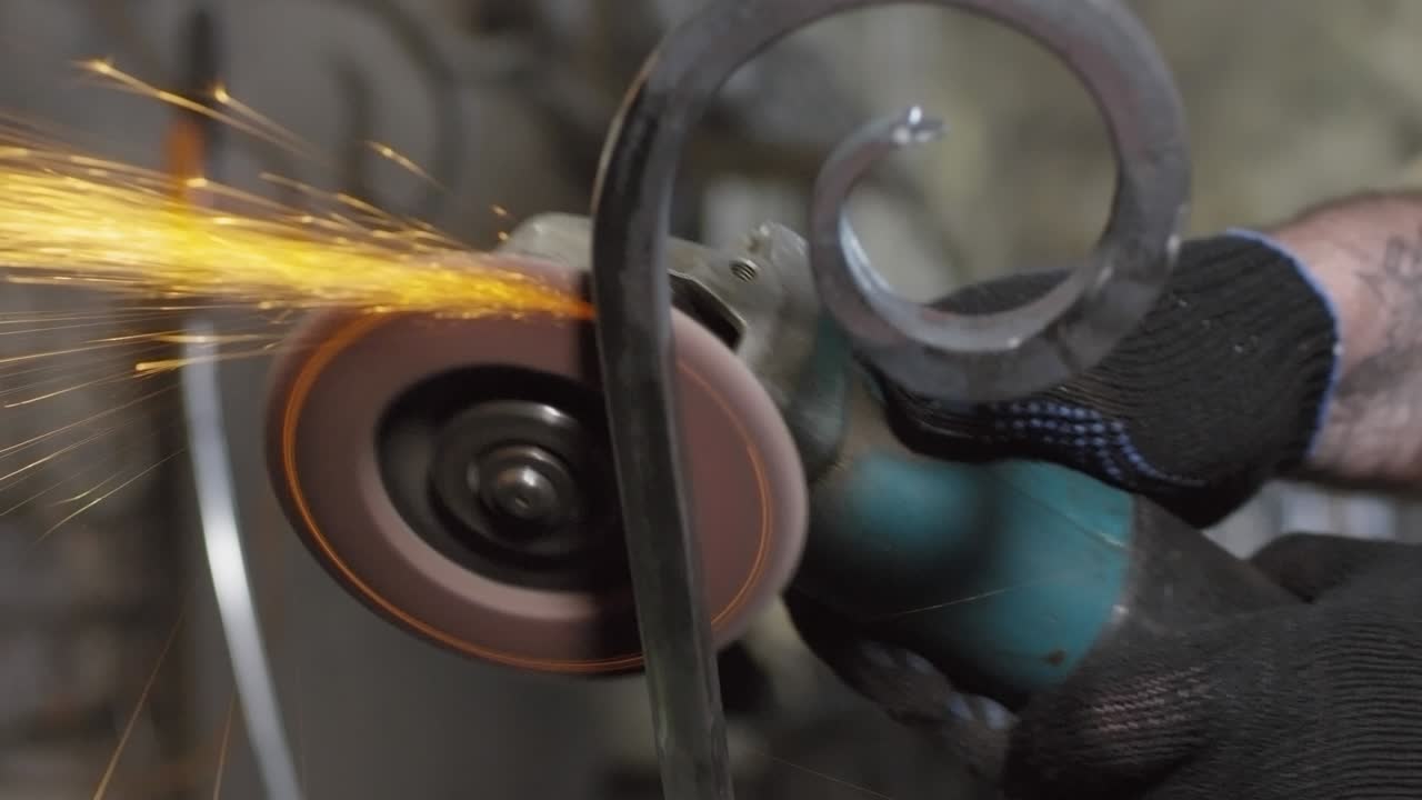 herrero moliendo metal en la herrería