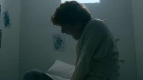 man with mental disorder struggling to escape straitjacket in white room
