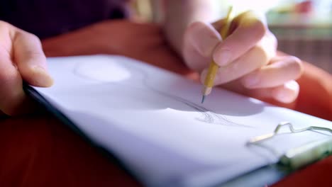 a focused artist captures inspiration on paper as they skillfully sketch a creative design with precise movements of a pencil and artistic intuition