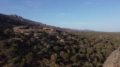 Slow-aerial-dolly-through-rock-formations-at-La-Pedriza,-Sierra-de-Guadarrama