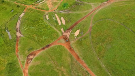 Toma-De-Drones-De-Motos-De-Cross-En-Una-Pista-Fangosa,-Vista-De-Drones-De-Arriba-Hacia-Abajo