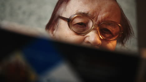 Old-woman-in-glasses-reading-a-book