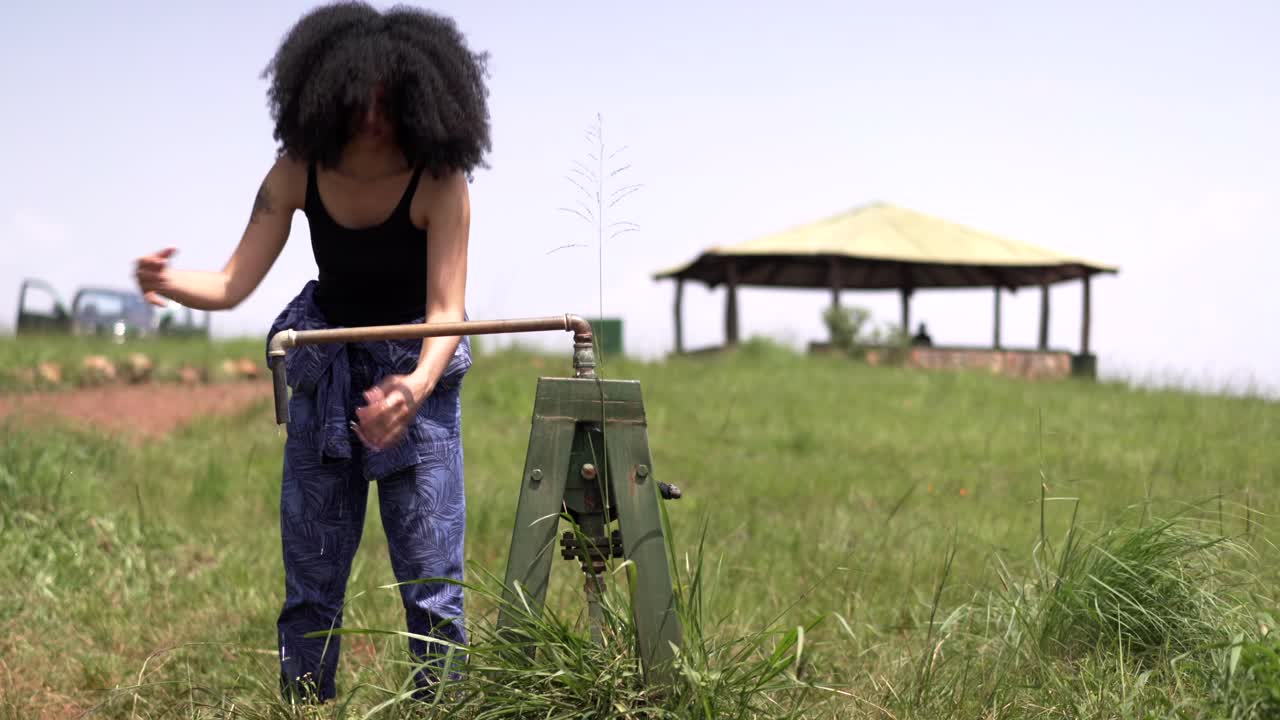 African girl pumping water pump for washing hands at Rwanda Africa