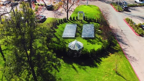 aerial drone ascending shot of an outdoor wedding venue with a gazebo by a clubhouse