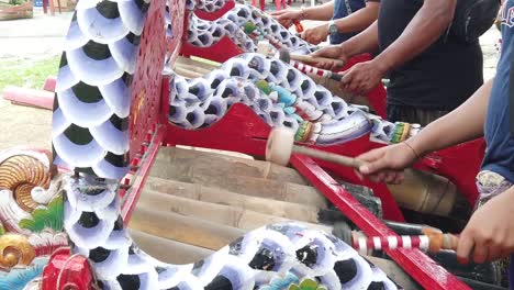 closeup hands of gamelan bamboo percussion musicians playing jegog balinese ensemble with interlocking movements, jembrana bali north regency indonesia