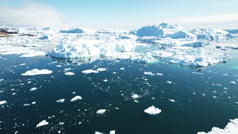 greenland coast with iceberg and deep blue water, aerial view