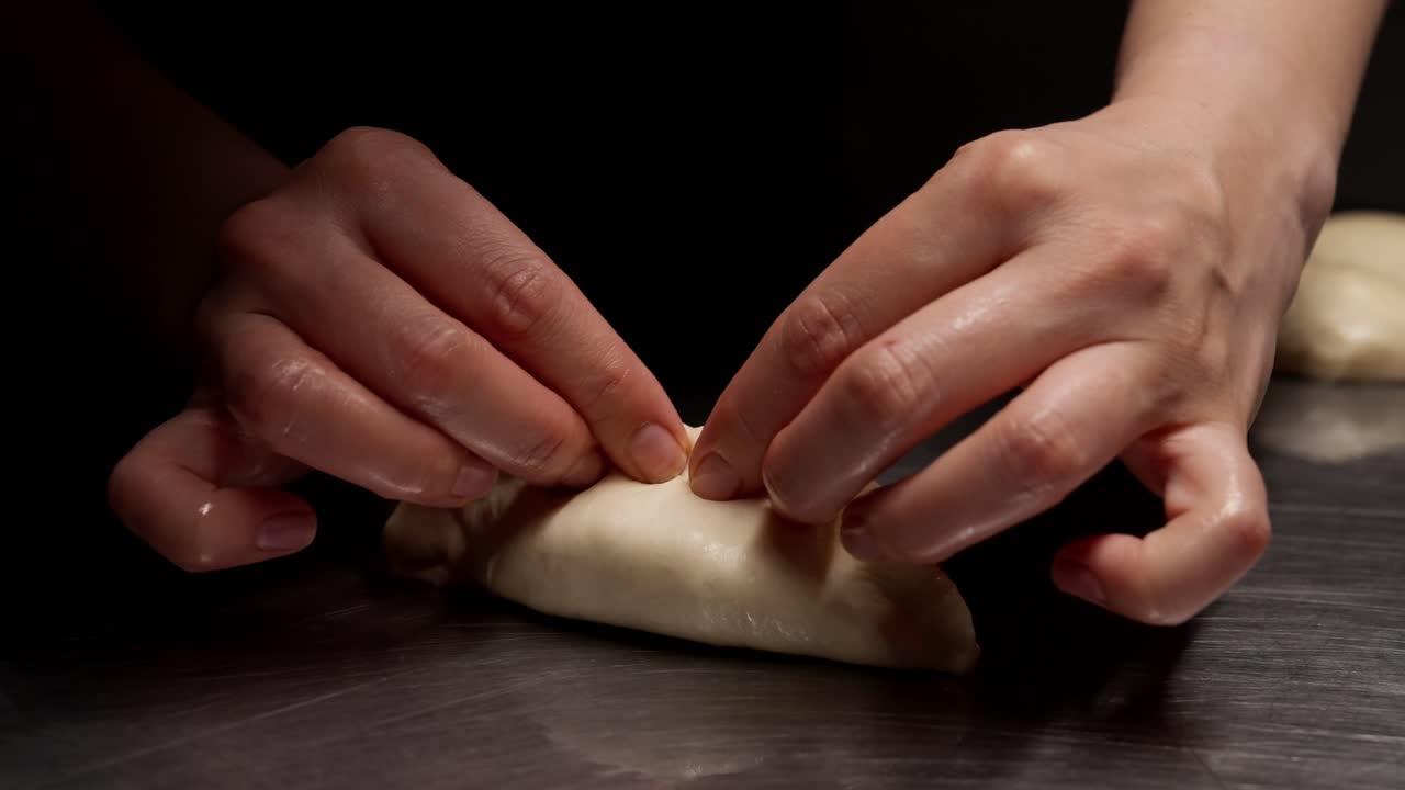 Primo piano di mani che modellano l'impasto per i ravioli