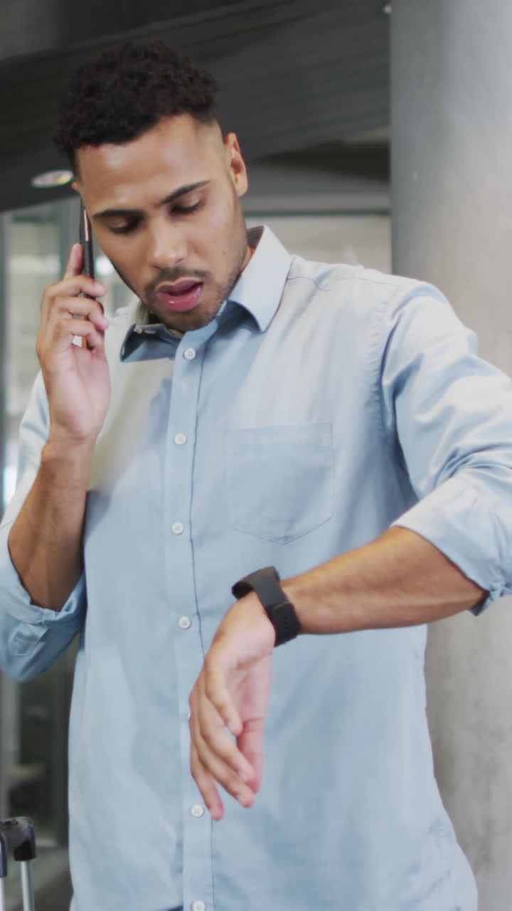 Video of biracial businessman using smartphone and checking watch
