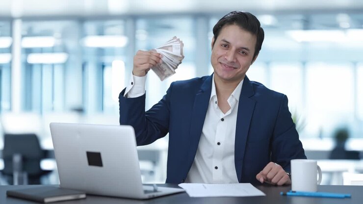 hombre de negocios indio usando dinero como ventilador feliz