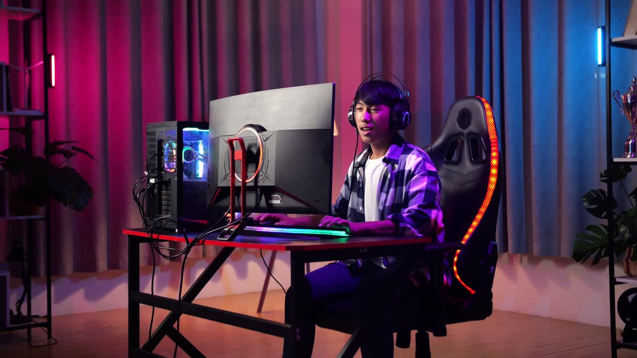 Excited Asian Teen Boy Gamer Playing Video Game On Computer