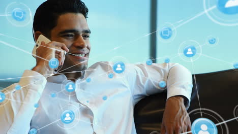 red de iconos de perfil contra el hombre biracial hablando en el teléfono inteligente en la oficina
