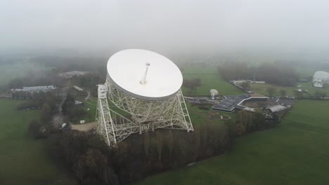 aerial jodrell bank observatory lovell telescope misty rural countryside slow rising push in