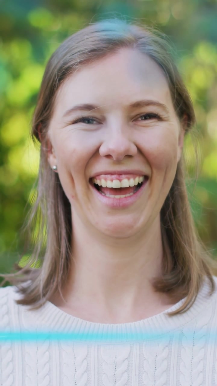 Vertical video: Woman smiling, laughing as blue scanline initiating expression shift for marketing