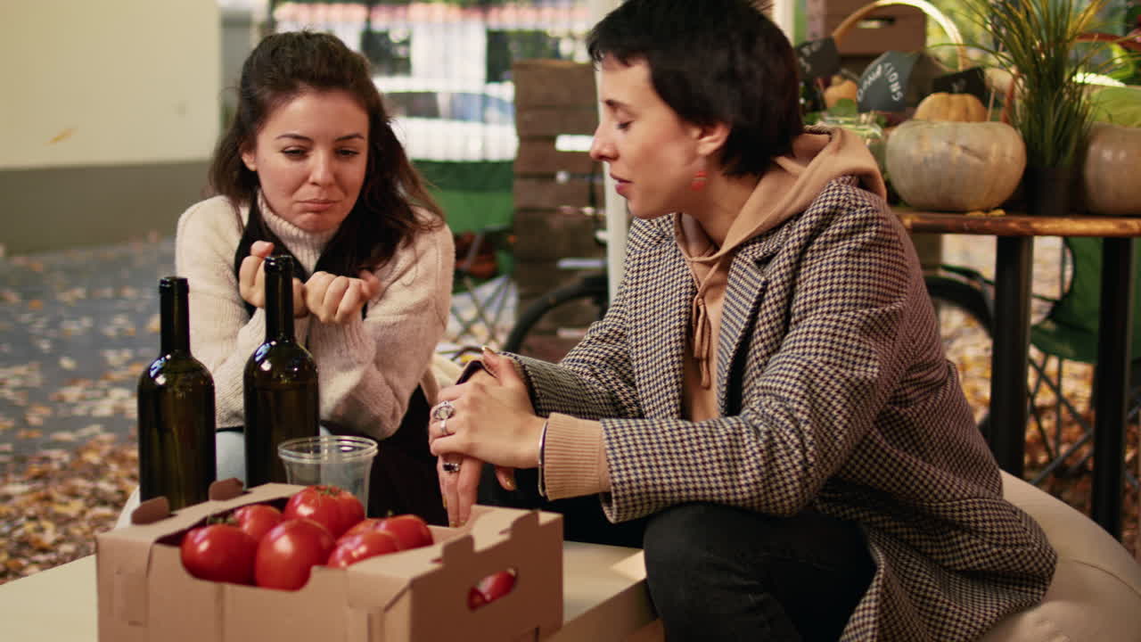 Two women chatting at an outdoor marketplace