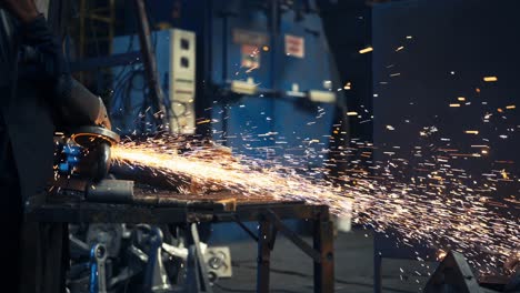 el trabajador de la fábrica está soldando con casco y gafas protectoras, las chispas vuelan del metal caliente