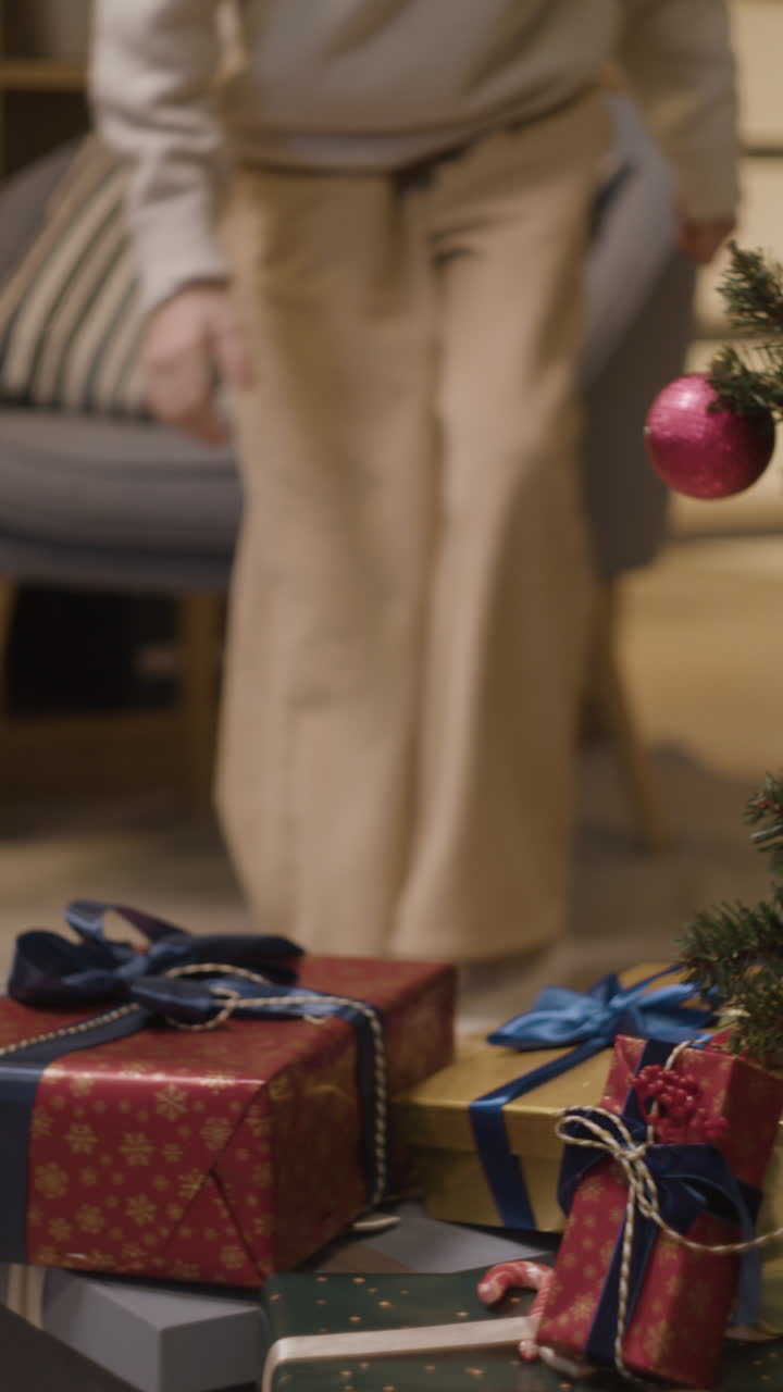 Girl carrying a gift near a Christmas tree