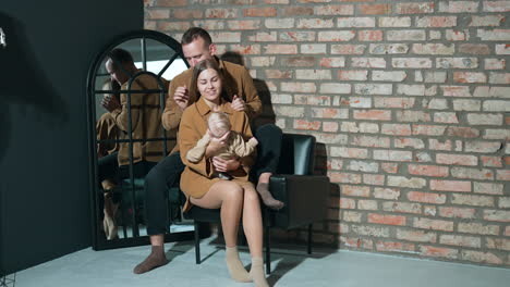 man caresses his wife waving a little baby. loving parents and caring spouses concept.