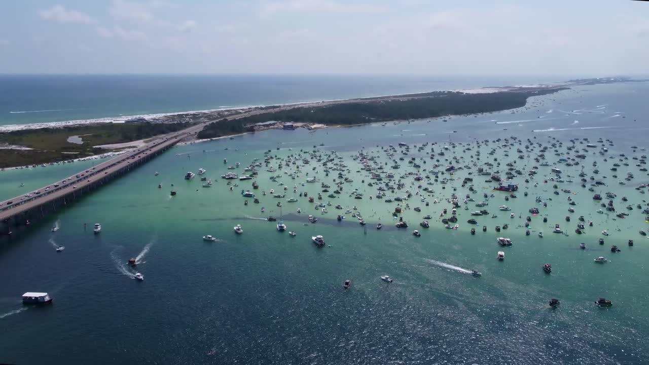 Distant Aerial View of Crab Island Off of Destin Florida. Crowd of people along with Vibrant fleet of yachts, pontoon boats adorn Crab Island, Florida's aerial view. Drone Shot of Crab Island Destin