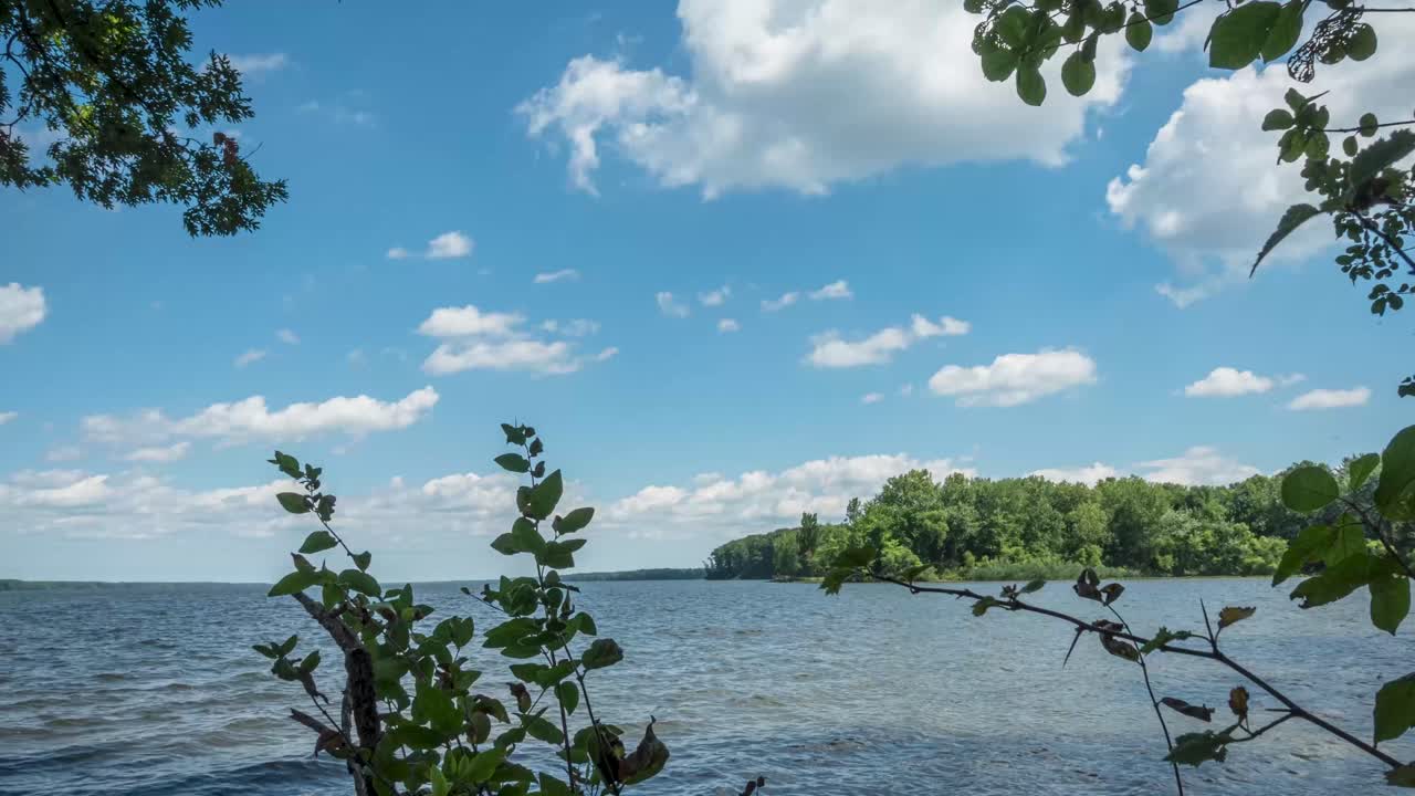 푸른 하늘과 산란한 구름으로 울창한 초록색으로 둘러싸인 호수의 조용한 풍경