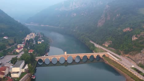 Aerial-of-the-famous-bridge-in-fog-over-the-drina-in-Visgerad,-Bosnia