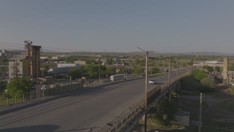 Ascending-shot-beside-a-railway-bridge-with-cars-travelling-along