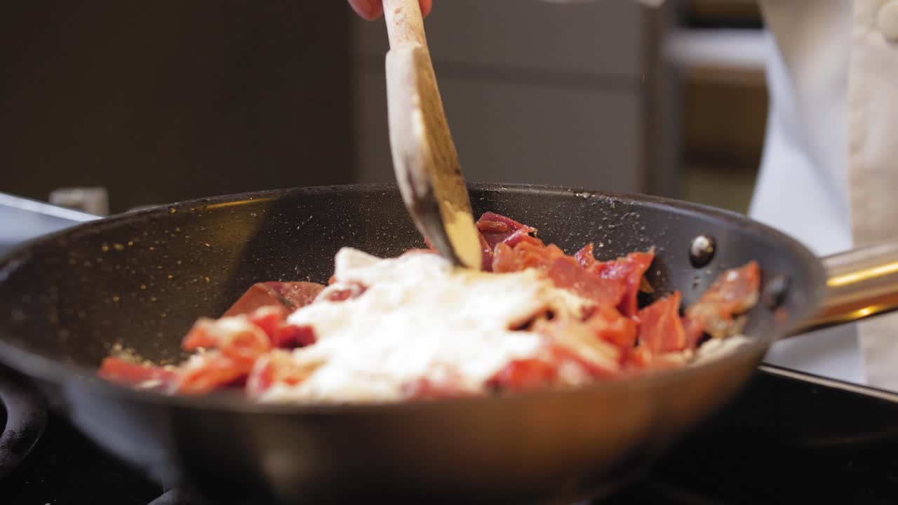 요리사는 팬에 밀가루로 햄을 뿌린다