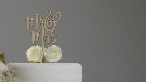 close up of wedding cake against grey studio background at wedding reception 1