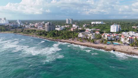 aerial estableciendo toma de dron que muestra enormes olas del mar del caribe alcanzando la costa de juan dolio con hoteles y villas