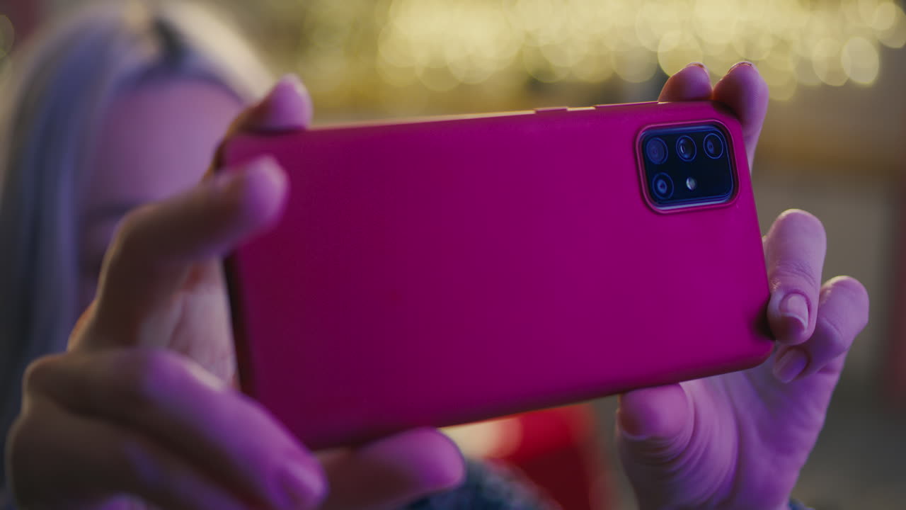 Woman taking a selfie with a red smartphone