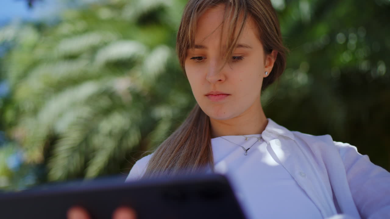 야외에서 태블릿을 사용하는 젊은 여성