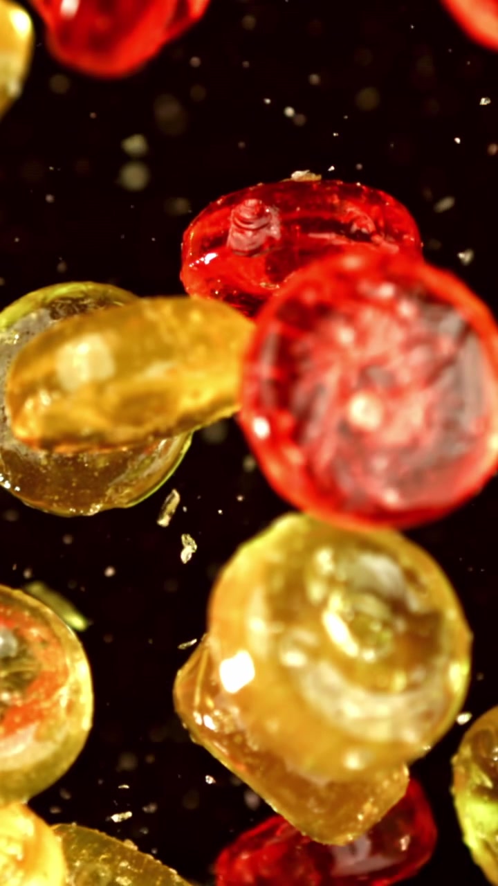 Red and Yellow Hard Candies Falling in Super Slow Motion