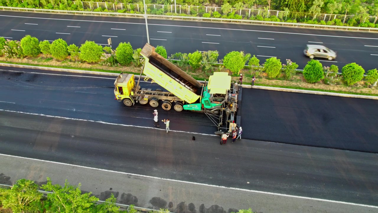 Prace budowlane nowej drogi asfaltowej na autostradzie ekspresowej obwodnicy Hyderabadu, ujęcie z drona 4K 30p