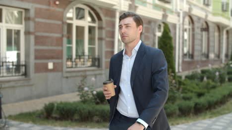 closeup man walking with coffee outdoor. man drinking coffee before work