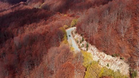 drone video follow car mountain winding road autumn forest colors kaimaktsalan