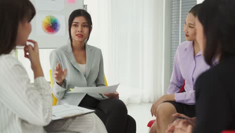 business people proficiently discuss work project while sitting in circle