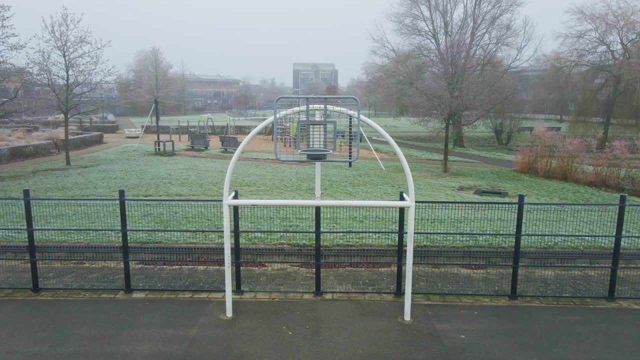 냉정하고 안개가 많은 아침에 공원에서 도시 농구장의 금속 허프의 돌리