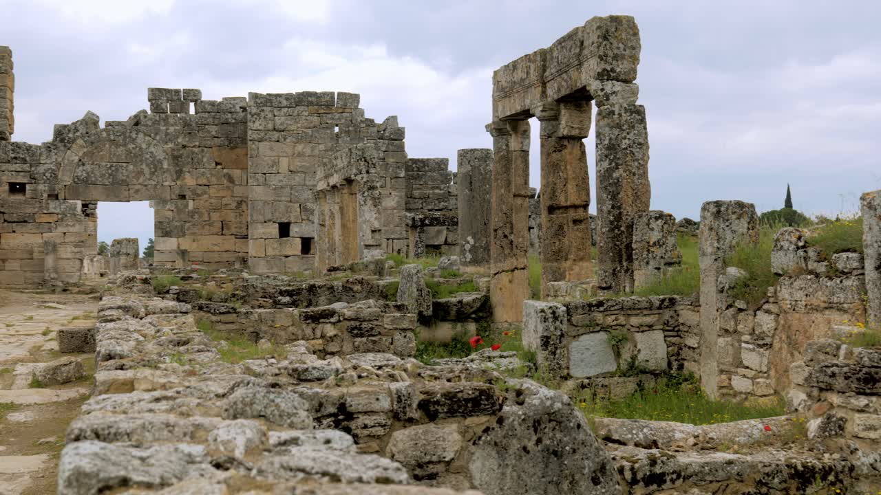 Pan shot to female tourist visiting unesco ancient Turkish city hierapolis