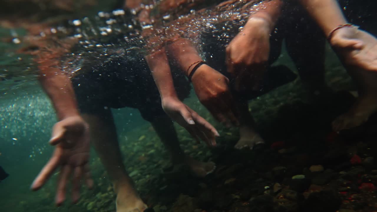 Close-up of Balinese dancer’s hands moving gracefully underwater in a river, wearing traditional costume, showcasing cultural expression, elegance, and fluid motion inspired by Bali heritage