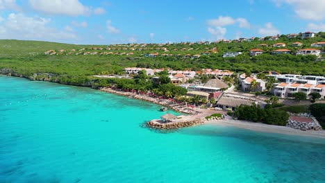 drone left to right orbit around caribbean villas as cloud shadow passes over white sand beach dramatically