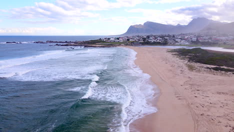 dolly aérea sobre kleinmond playa de bandera azul hacia la laguna y la ciudad costera