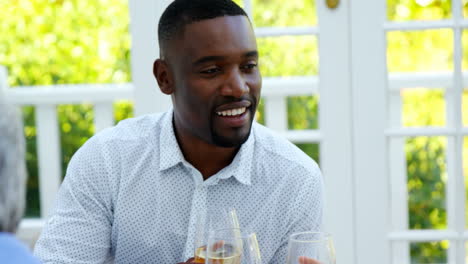 Man-interacting-while-having-wine-in-restaurant