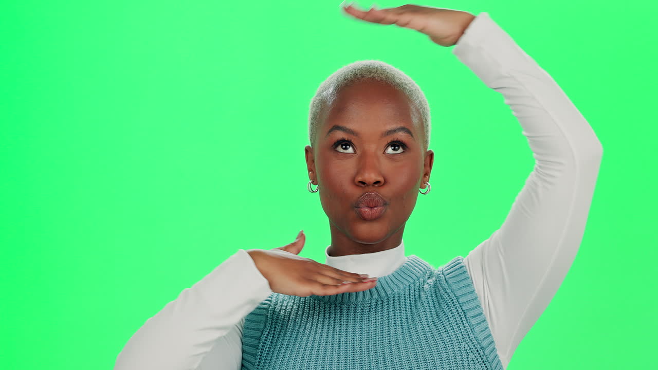 A woman gesturing in front of a green screen