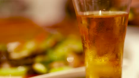 close-up of beer glasses in a warm-lit chinese restaurant setting, highlighting a relaxed dining atmosphere