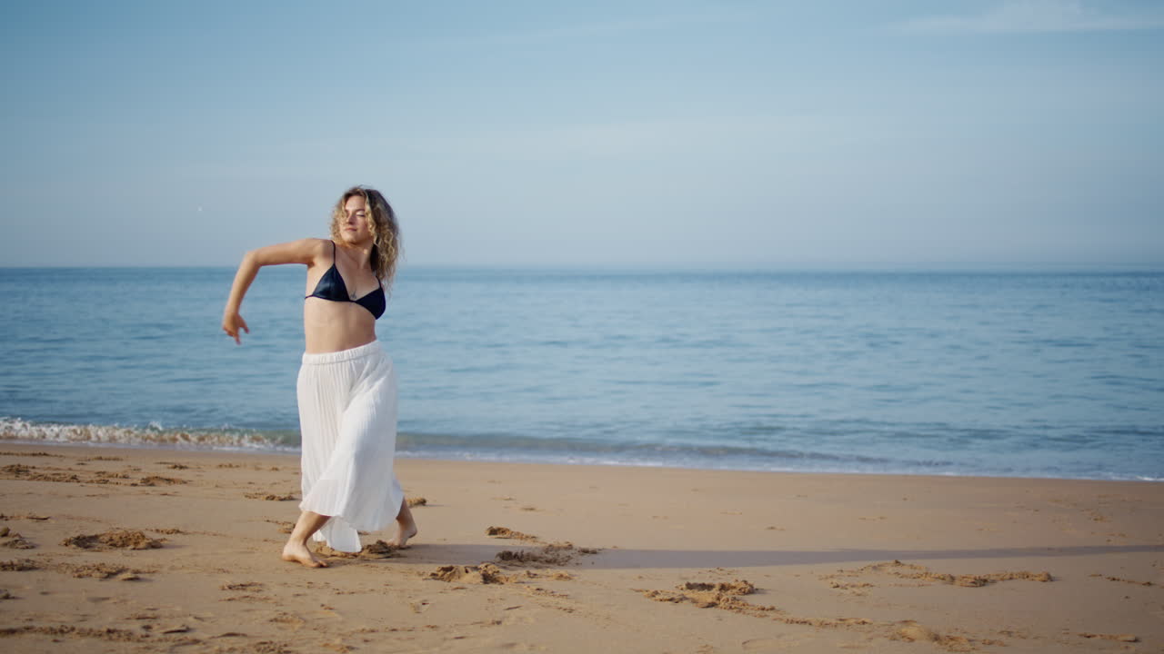 바다 연안에서 동시대 춤을 연습하는 소녀 댄서