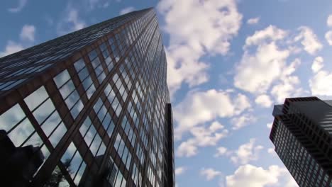 a stunning perspective of a towering skyscraper against a beautiful cloudy sky, capturing the intricate details of glass and architecture in urban landscapes