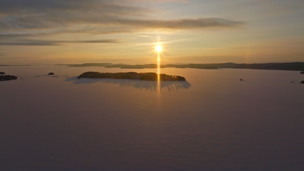 공중: 핀란드 북 카리아의 피엘리네 호수 섬 위의 겨울 해가 뜨는 모습