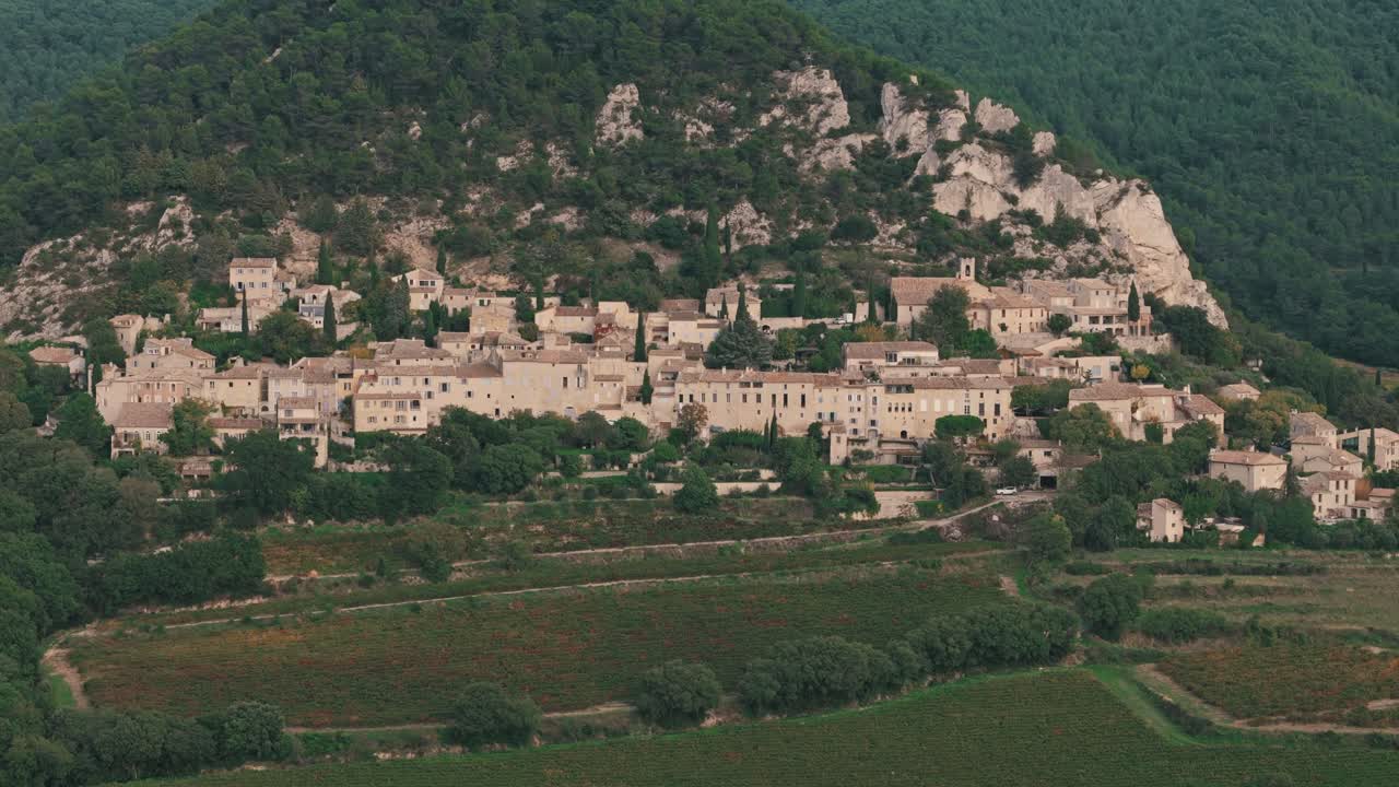 Aerial circle right establishing overview of Seguret village in Provence, France, highlighting the charming architecture and hillside landscape