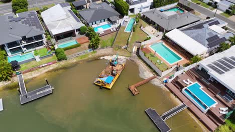 drone footage captures construction work on a canal in broadbeach waters, showcasing urban development and waterfront properties