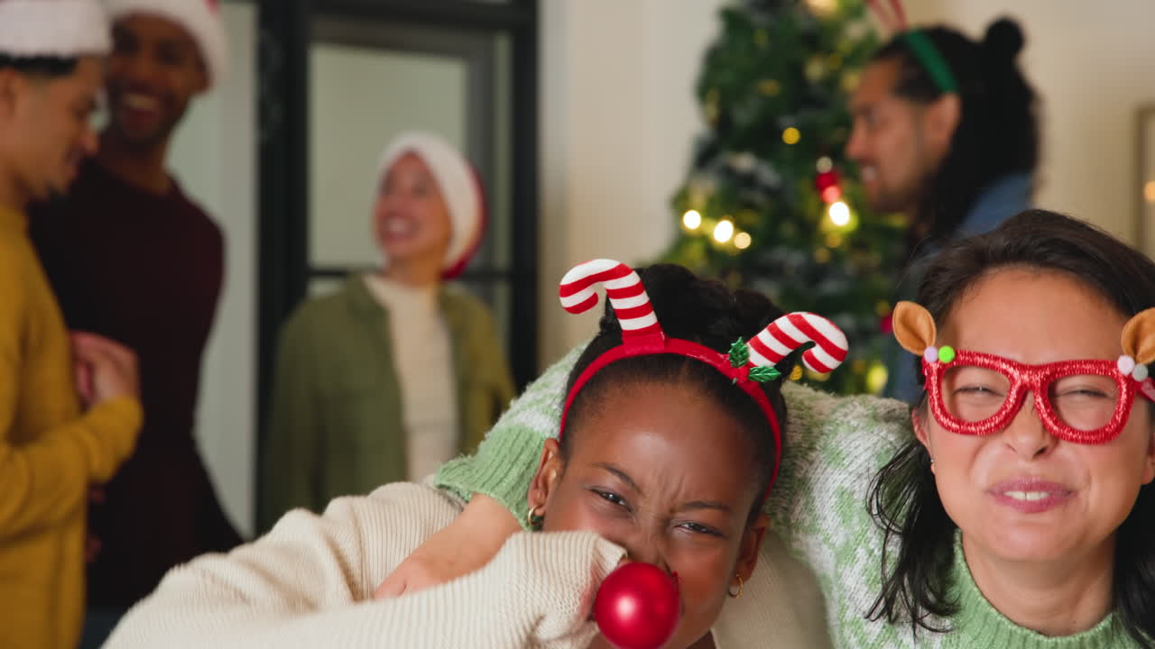 Young diverse friends celebrating Christmas with festive headbands and joyful laughter
